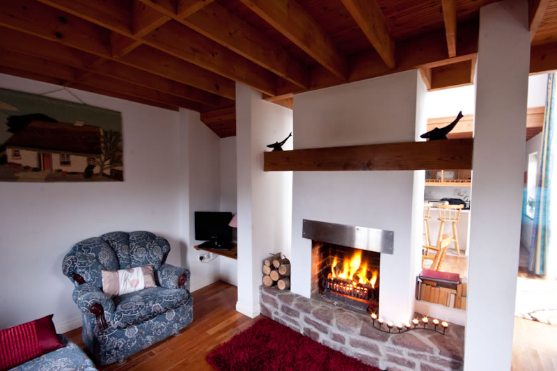 View of lounge area with open turf fire at Achill Cottages